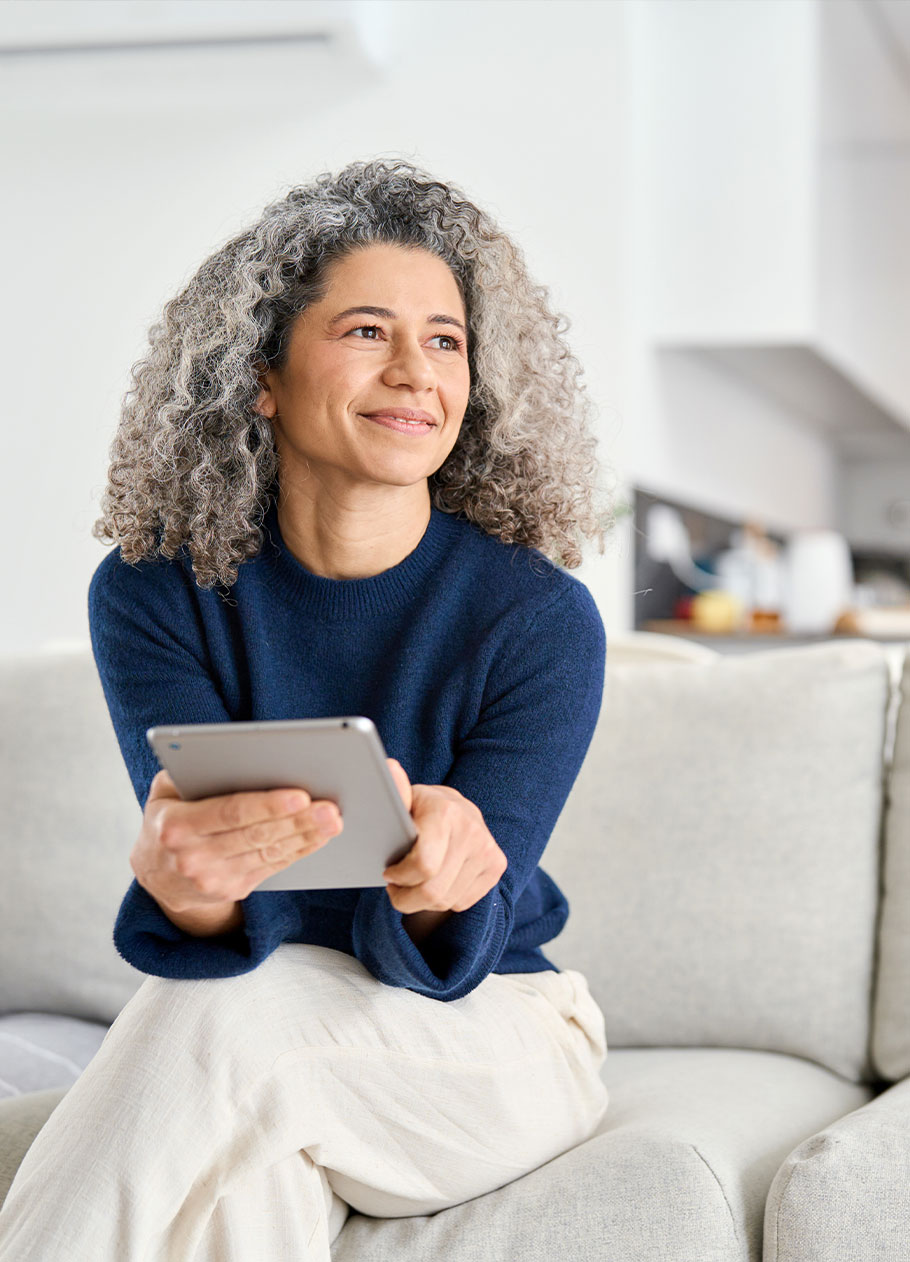 Woman sitting on couch thinking about her dream home. 
